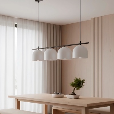 Lustre suspenso com quatro cúpulas brancas sobre mesa de madeira clara