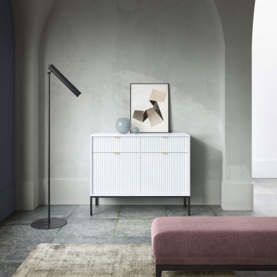 Cómoda branca com texturas verticais e decoração minimalista num ambiente interior moderno