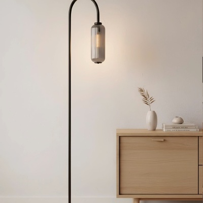 Candeeiro de pé preto com abajur de vidro cinzento ao lado de móvel de madeira clara e decoração minimalista