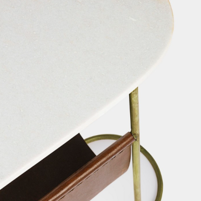 Mesa com tampo oval em pedra clara, estrutura metálica verde-oliva e bolsa em couro castanho