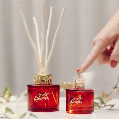 Frascos vermelhos Lolita Lempicka com difusor de varetas e spray em fundo claro