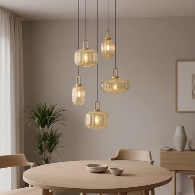 Candeeiros pendentes de vidro cor de mel com mesa de madeira clara e cadeiras em ambiente minimalista