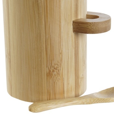 Caneca de madeira com colher de madeira sobre fundo branco