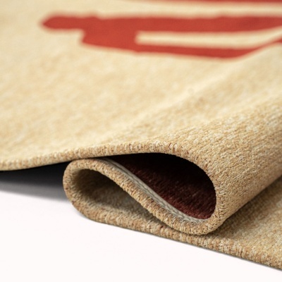 Tapete bege e vermelho dobrado mostrando a textura e a cor castanha da parte de trás.