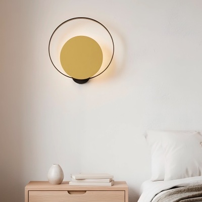 Candeeiro de parede moderno sobre mesa-de-cabeceira com vaso e livros ao lado de cama