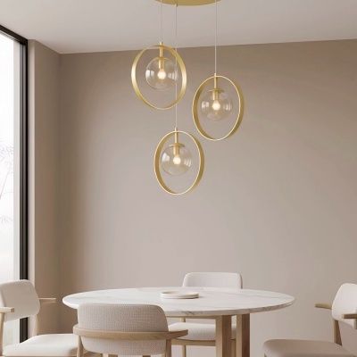 Mesa de jantar redonda branca com cadeiras bege em ambiente minimalista e lâmpadas pendentes douradas.