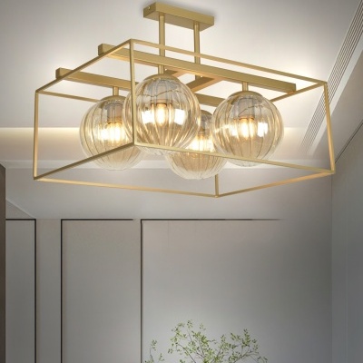 Lustre moderno dourado com globos de vidro transparente no teto.