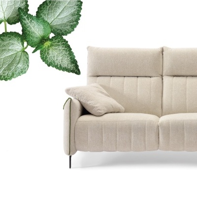 Sofá de tecido bege com almofada e plantas verdes ao lado