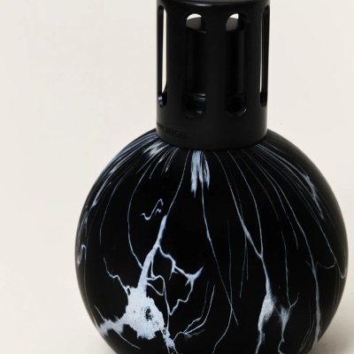 Frasco redondo preto com padrão branco e tampa preta perfurada