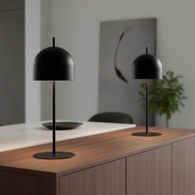 Duas lâmpadas de mesa negras sobre mesa de madeira num ambiente moderno.