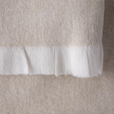 Tecido bege com borda branca e textura aveludada