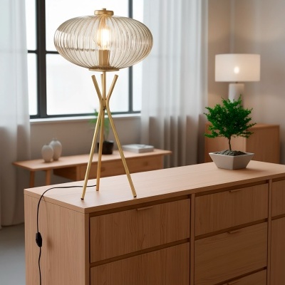 Candeeiro de mesa dourado com cúpula de vidro estriada em móvel de madeira clara