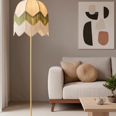 Lâmpada de pé com abajur bege e verde ao lado de sofá bege e mesa de madeira