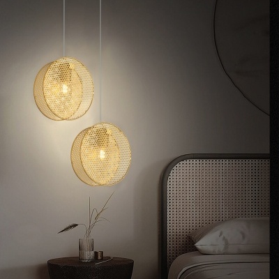 Candeeiros de tecto circulares dourados iluminados junto a cama com cabeceira trançada e mesa de cabeceira preta com vaso