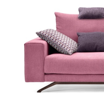 Sofá rosa com almofadas roxas e padrão geométrico