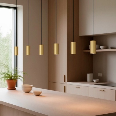 Cozinha moderna com pendentes dourados e banco em madeira clara.