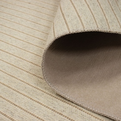 Tapete bege com riscas castanhas e dobra mostrando o verso.
