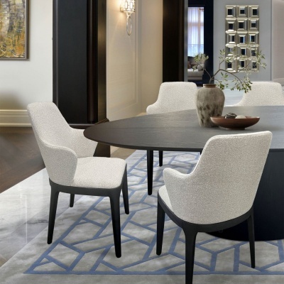 Mesa de jantar redonda preta com quatro cadeiras estofadas brancas sobre tapete cinza com padrões azuis