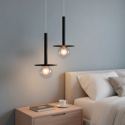 Quarto com candeeiros pendentes em vidro e metal preto, mesa de cabeceira em madeira clara, cama com roupa branca e parede cinzenta.