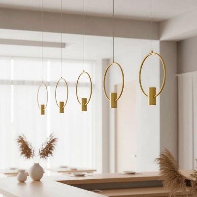 Cinco luminárias pendentes douradas em forma de círculo num espaço interior claro