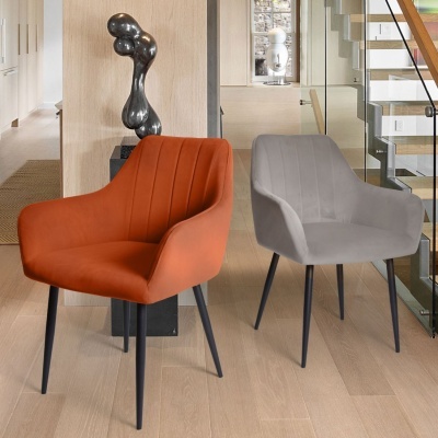 Duas cadeiras estofadas laranja e cinza com pernas pretas ao lado de escada de vidro e madeira