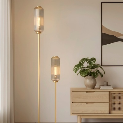 Lâmpada de pé dupla dourada com abajures de vidro ao lado de móvel de madeira clara