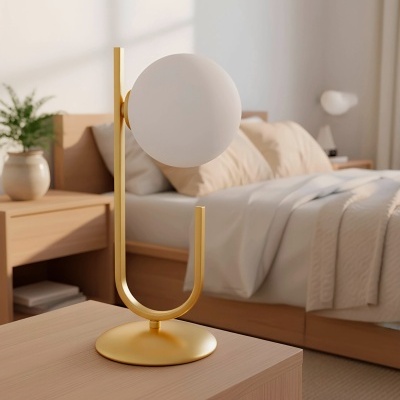 Candeeiro de mesa dourado com abajur branco num quarto moderno