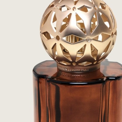 Difusor de fragrância de vidro marrom com tampa dourada vazada e texto Maison Berger Paris
