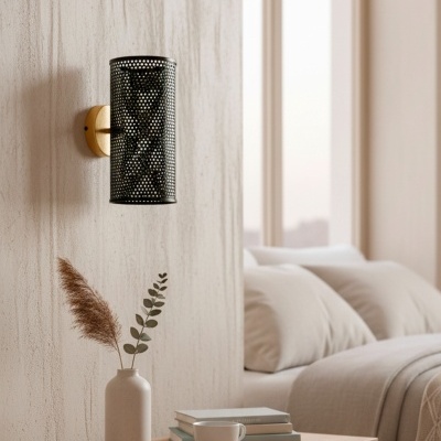 Candeeiro de parede metálico preto perfurado com base dourada em quarto com mesa de cabeceira e cama