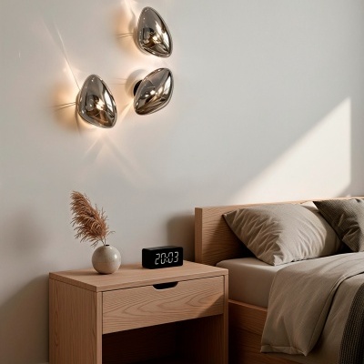 Mesa de cabeceira e cama em madeira clara com decoração minimalista e luzes metálicas na parede