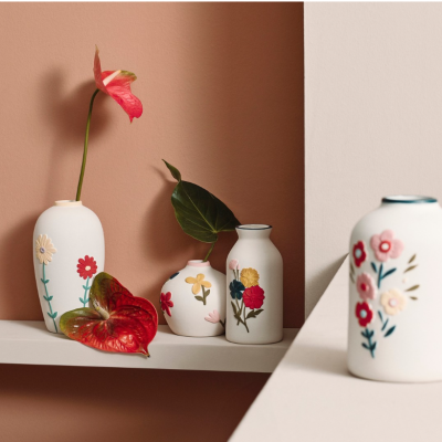 Jarros de cerâmica brancos com flores coloridas em relevo e flores de antúrio