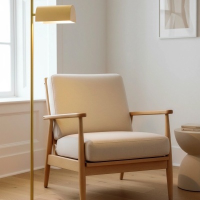 Poltrona bege com estrutura de madeira clara e candeeiro de pé dourado