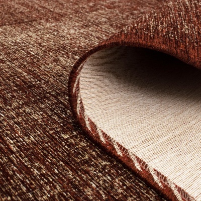 Tapete castanho com padrão salpicado, dobra para mostrar verso bege liso