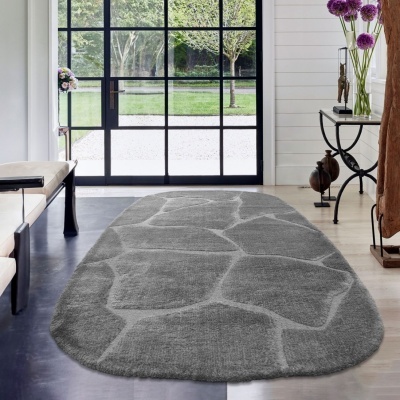 Tapete cinzento com padrão de pedras em relevo numa sala com janela grande e chão claro