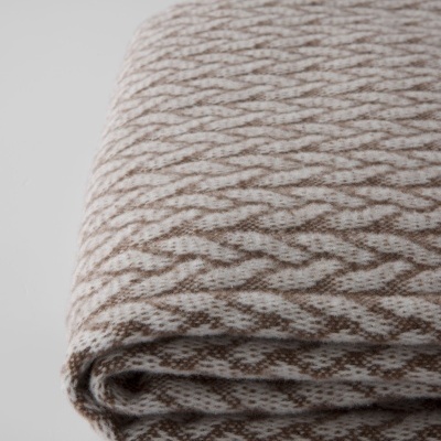 Manta dobrada branca e castanha com padrão geométrico