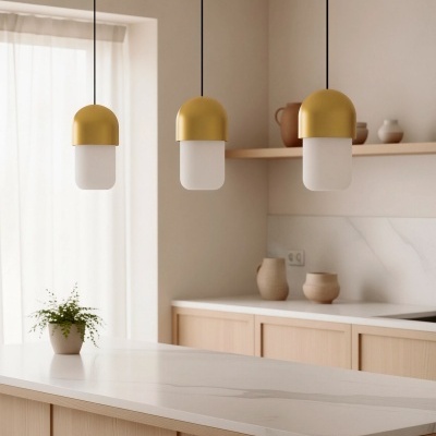 Cozinha com ilha, luminárias pendentes douradas, ornamentos cerâmicos e planta pequena