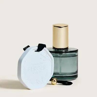 Frasco de vidro com tampa dourada e etiqueta branca em relevo com texto MAISON BERGER PARIS
