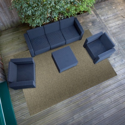 Conjunto de móveis de exterior em rattan azul escuro com tapete bege numa plataforma de madeira