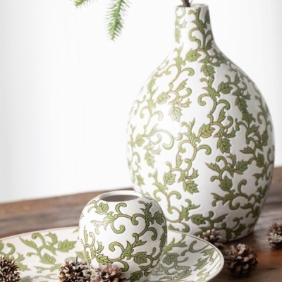 Conjunto cerâmico decorativo branco com padrão de folhas verdes, pinhas e ramo verde