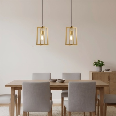 Sala de jantar com mesa de madeira clara, cadeiras cinza, duas lâmpadas pendentes douradas e móvel de madeira com planta.