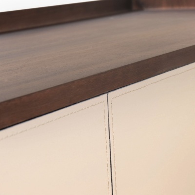 Gavetas de madeira clara com tampo de madeira escura e costuras decorativas.