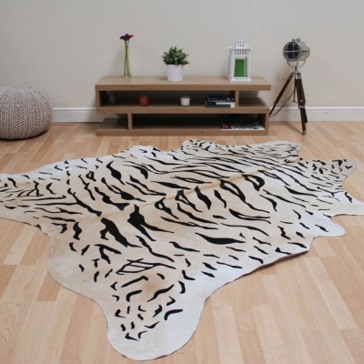 Tapete zebrado preto e branco sobre chão de madeira em sala com móvel e decoração