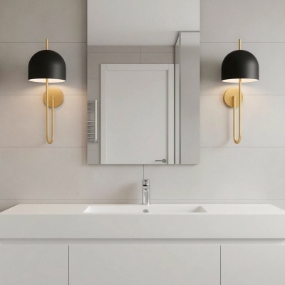 Casa de banho com lavatório branco, espelho retangular e duas arandelas pretas e douradas numa parede cinzenta.