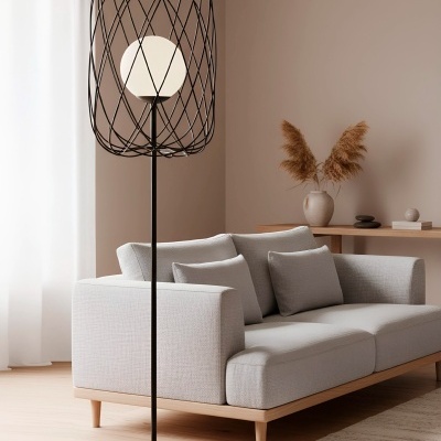 Luminária de pé preta com esfera branca, sofá cinza claro, tapete bege e mesa com jarro de plantas secas