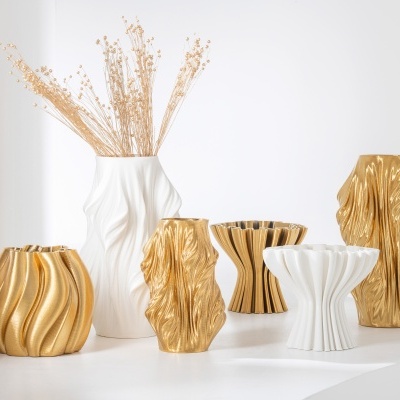 Seis vasos decorativos brancos e dourados com texturas onduladas em fundo branco