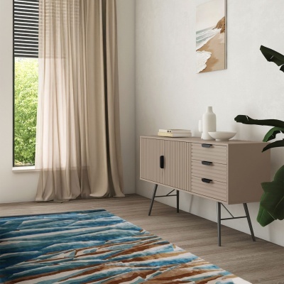 Móvel buffet bege com gavetas e portas, cortinas bege, tapete azul e castanho, pintura de praia na parede branca