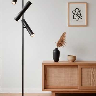 Lâmpada de pé preta com três focos e móvel de madeira clara com decoração