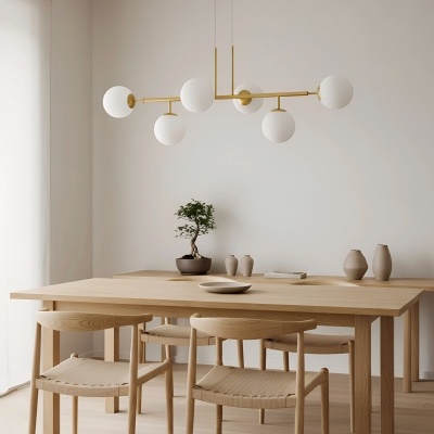Sala de jantar minimalista com mesa de madeira clara e candeeiro suspenso moderno com globos brancos.