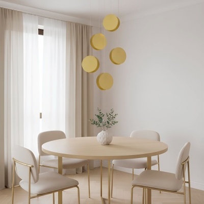 Mesa de jantar redonda com cadeiras bege e candeeiro suspenso dourado num ambiente claro e minimalista
