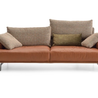 Sofá de três lugares em pele castanha com almofadas de tecido texturado e almofada verde